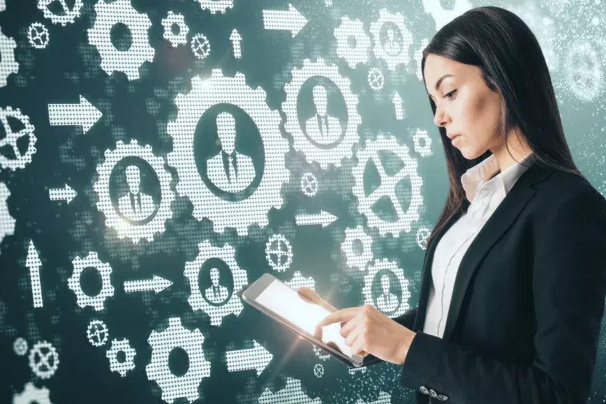 A professional reviewing job workflow management tasks on a digital screen with charts and planning tools in an office setting.