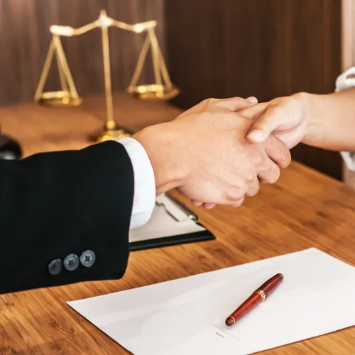 Hands shaking after agreeing on a legal document management system